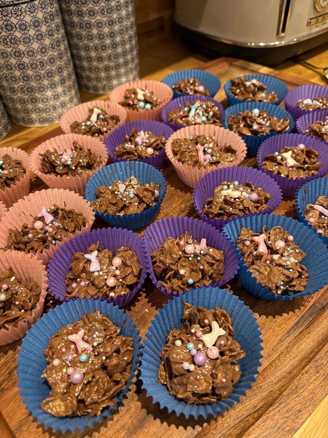 Chocolate cornflake cakes with pastel sprinkles in coloured cases