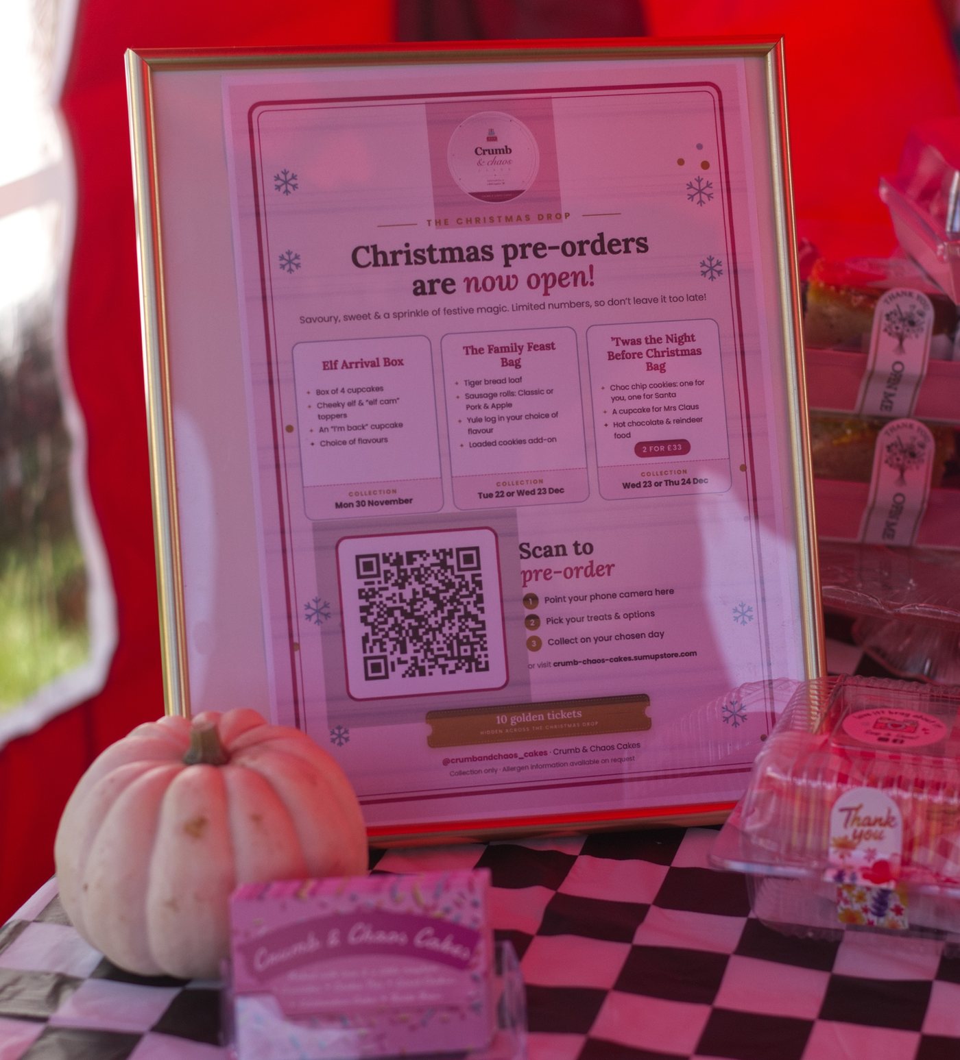 Framed Christmas pre-order sign with a QR code on the Crumb & Chaos Cakes market stall